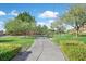 A serene park with lush green grass, mature trees, and a walking path under a sunny sky at 1026 Via Saint Andrea Pl, Henderson, NV 89011