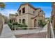 Tan stucco complex exterior with arched entryways, landscaping, and accessible ramp at 10270 Gilmore Canyon Ct # 202, Las Vegas, NV 89129