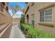 Exterior walkway with green bushes in front of a light brown stucco building at 10270 Gilmore Canyon Ct # 202, Las Vegas, NV 89129