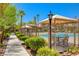 Tranquil pool area with shaded seating, well-maintained hedges, and a paved walkway at 10270 Gilmore Canyon Ct # 202, Las Vegas, NV 89129