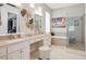 Bright bathroom featuring double sinks, vanity, soaking tub, glass shower, and private commode at 10640 Mission Lakes Ave, Las Vegas, NV 89134