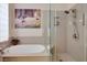 Bathroom features a soaking tub with a tiled shower and vanity with quartz countertop at 10640 Mission Lakes Ave, Las Vegas, NV 89134