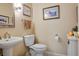 Well lit powder room features a pedestal sink and framed artwork on the walls at 10640 Mission Lakes Ave, Las Vegas, NV 89134