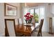 Formal dining room featuring a wood table, seating for six, and bright natural light through sheer window coverings at 10640 Mission Lakes Ave, Las Vegas, NV 89134