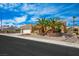 Inviting single-story home featuring a two-car garage, desert landscaping, and mature palm trees at 10640 Mission Lakes Ave, Las Vegas, NV 89134