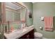 Bathroom with a dark wood vanity, granite countertop, and a framed mirror above at 111 Narcissus Ln, Las Vegas, NV 89107