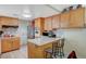 Kitchen featuring wooden cabinets, tile backsplash, and a breakfast bar with seating at 111 Narcissus Ln, Las Vegas, NV 89107