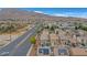 An aerial view of a neighborhood with two-story homes and red tile roofs and solar panels with mountains at 1131 Orange Meadow St, Las Vegas, NV 89142