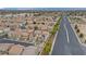 A sprawling neighborhood with two-story homes and red tile roofs and solar panels with city backdrop at 1131 Orange Meadow St, Las Vegas, NV 89142