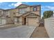 Charming two-story home with a tan exterior, a concrete driveway, and a one car garage at 1131 Orange Meadow St, Las Vegas, NV 89142