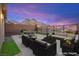 Spacious backyard patio area with outdoor seating, mountain views, and a brick privacy fence at 11676 Midnight Melody Ave, Las Vegas, NV 89138