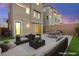 Backyard patio with comfortable seating, dining area, and manicured lawn at 11676 Midnight Melody Ave, Las Vegas, NV 89138