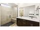 Modern bathroom featuring double vanity, tile shower, and a large mirror at 11676 Midnight Melody Ave, Las Vegas, NV 89138