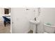 A modern bathroom with white pedestal sink, oval mirror, and sleek black fixtures, offering a clean and contemporary space at 11676 Midnight Melody Ave, Las Vegas, NV 89138