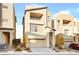 A modern three-story home featuring a neutral color palette, balcony, attached garage, and landscaped front yard at 11676 Midnight Melody Ave, Las Vegas, NV 89138