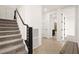 Well-lit hallway with stairs and neutral tile flooring, offering access to various rooms at 11676 Midnight Melody Ave, Las Vegas, NV 89138