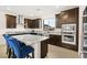 Modern kitchen featuring dark cabinets, a large granite island with seating, and stainless steel appliances at 11676 Midnight Melody Ave, Las Vegas, NV 89138