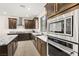 Gourmet kitchen featuring stainless steel appliances and dark wood cabinetry at 11676 Midnight Melody Ave, Las Vegas, NV 89138