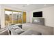 Bright and spacious living room with modern fireplace, plush seating, and access to outdoor balcony with neighborhood views at 11676 Midnight Melody Ave, Las Vegas, NV 89138