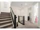Carpeted staircase with modern black railings leading to the upper level, with natural light at 11676 Midnight Melody Ave, Las Vegas, NV 89138