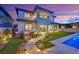 A backyard features a pool, landscaped area, and a covered patio at twilight at 11878 Albissola Ave, Las Vegas, NV 89138