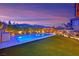 An outdoor oasis with a pool, landscaped backyard, and a covered patio at twilight at 11878 Albissola Ave, Las Vegas, NV 89138