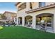 Spacious backyard featuring artificial turf, beautiful landscaping, a covered patio, and exterior architecture at 11878 Albissola Ave, Las Vegas, NV 89138