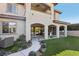 Home's backyard featuring artificial turf, beautiful landscaping, a covered patio, and exterior architecture at 11878 Albissola Ave, Las Vegas, NV 89138