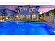 Beautiful backyard with a sparkling pool and lush landscaping that complements the architecture of the home at 11878 Albissola Ave, Las Vegas, NV 89138