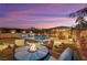 Serene backyard featuring a pool, spa, manicured lawn, built in BBQ and comfortable seating area with fire pit at 11878 Albissola Ave, Las Vegas, NV 89138