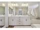 Well-lit bathroom with a double sink vanity, modern fixtures, white tile, and a glass-enclosed shower space at 11878 Albissola Ave, Las Vegas, NV 89138
