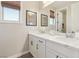 Bright bathroom offers a dual sink vanity with white cabinets, countertop, and mirror at 11878 Albissola Ave, Las Vegas, NV 89138