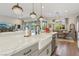 Bright, open-concept kitchen featuring a farmhouse sink, marble countertops and pendant lighting at 11878 Albissola Ave, Las Vegas, NV 89138