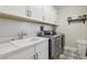 A modern laundry room features modern appliances and custom cabinets for an organized space at 11878 Albissola Ave, Las Vegas, NV 89138