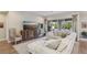 Bright living room features a sectional sofa, patterned console, hardwood floors, and large sliding glass doors to backyard at 11878 Albissola Ave, Las Vegas, NV 89138