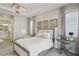 Bright bedroom featuring a decorative chandelier, neutral colors, and an ensuite bathroom providing a peaceful retreat at 11878 Albissola Ave, Las Vegas, NV 89138