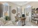 This home office has arched windows, neutral walls, and a wooden desk with a comfortable chair and a seating area at 11878 Albissola Ave, Las Vegas, NV 89138