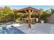 Outdoor kitchen featuring stainless steel appliances under a covered gazebo, adjacent to the pool at 11878 Albissola Ave, Las Vegas, NV 89138