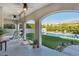 Covered patio with hanging chairs overlooking a pool and green backyard at 11878 Albissola Ave, Las Vegas, NV 89138