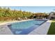 Sparkling pool with a concrete surround, an outdoor kitchen under a gazebo, and lounge chairs create a relaxing outdoor space at 11878 Albissola Ave, Las Vegas, NV 89138