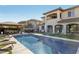 Inviting pool with outdoor kitchen and lounge chairs set against the backdrop of a well-appointed home at 11878 Albissola Ave, Las Vegas, NV 89138