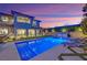 An outdoor oasis with a pool, landscaped backyard, and a covered patio at twilight at 11878 Albissola Ave, Las Vegas, NV 89138