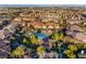 Expansive aerial view of a residential community with lush landscaping, resort-style pool, and mountain backdrop at 11890 Tevare Ln # 1098, Las Vegas, NV 89138