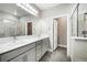 A gray spa-like bathroom features a double vanity and a gray-tiled shower and tub at 11890 Tevare Ln # 1098, Las Vegas, NV 89138
