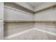 An empty gray walk-in closet features white trim and wooden closet rods at 11890 Tevare Ln # 1098, Las Vegas, NV 89138
