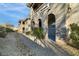 Stucco building featuring a covered walkway with arched openings and desert landscaping at 11890 Tevare Ln # 1098, Las Vegas, NV 89138