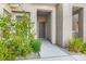Home's front door with desert landscaping and an attached garage at 11890 Tevare Ln # 1098, Las Vegas, NV 89138