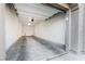 Open garage with concrete flooring, white walls, and door leading to a side yard at 11890 Tevare Ln # 1098, Las Vegas, NV 89138