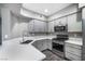 This kitchen features stainless steel appliances, lots of natural light and grey cabinetry at 11890 Tevare Ln # 1098, Las Vegas, NV 89138
