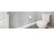 A white toilet sits in a gray bathroom with white trim and gray floors at 11890 Tevare Ln # 1098, Las Vegas, NV 89138